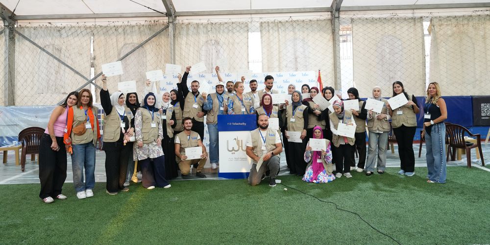 متطوعو تاليا يحملون شهاداتهم في صورة جماعية خلال نشاط مجتمعي.